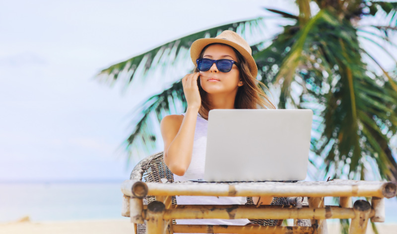 Das Foto zeigt eine junge Frau, die als »Digital Nomad« am Strand arbeitet. Dies Foto entspricht einer einfachen Affirmation, im Gegensatz zu einer hochwertigen Affirmation, bei der der Affirmierende sein Ziel mit allen 5 Sinnen wahrnimmt. 