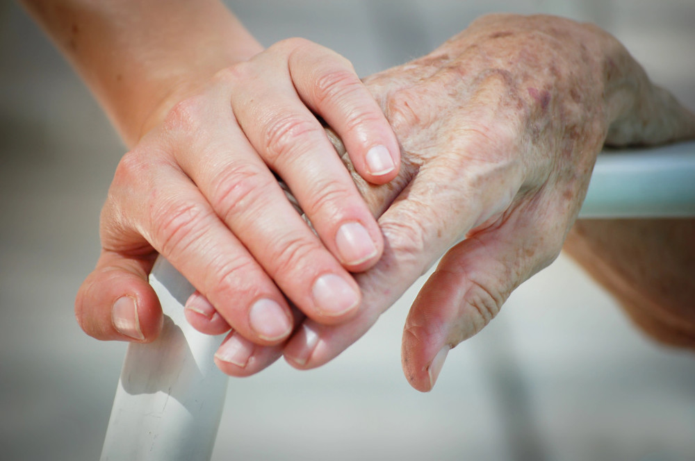 Das Foto zeigt eine junge Hand eines jungen Menschen, der die Hand eines älteren Menschen berührt - Symbol für Verbundenheit und Mitgefühl. Auf diese Qualitäten geht Barbara Nobis in ihrer Rezension des Buches "Bin ich traumatisiert" ein. 